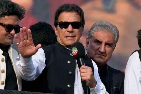 Players standing beside Imran Khan after he gets injured in gunfire attack